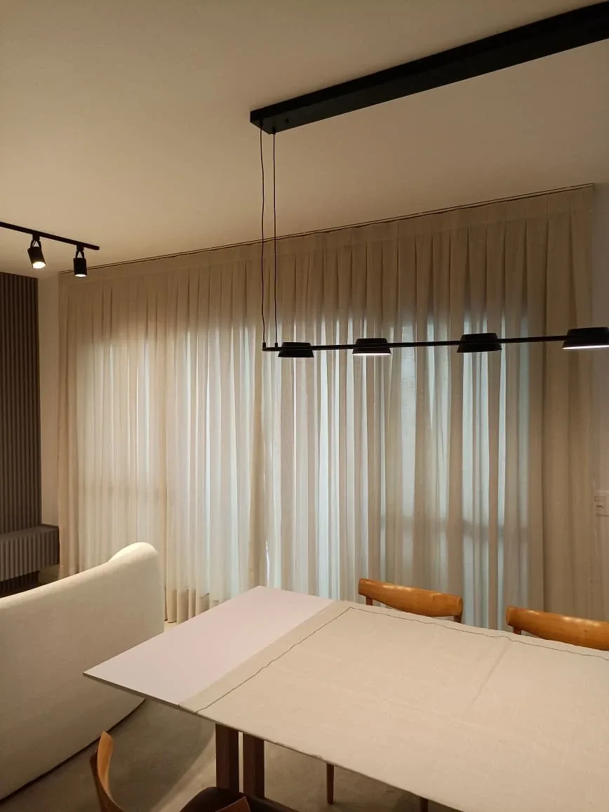 Sala de jantar contemporânea com cortinas claras do piso ao teto
